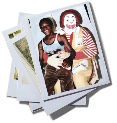 photograph of a child sitting on the lap of a man dressed as ronald mcdonald